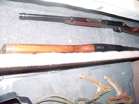 1989 Ford Bronco - Two firearms are visible in the back of a vehicle, along with jumper cables and clamps.