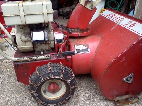1988 Ford F-150 - Close-up of a red snow blower, identified as 'Artic 75', a gas engine and tire chains.