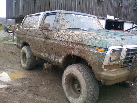 1979 Ford Bronco - This heavily mud-caked 1978 Ford Bronco is parked in front of a wooden barn.