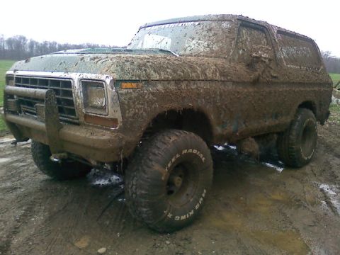 1979 Ford Bronco - This heavily mud-caked 1979 Ford Bronco is shown in a three-quarter front view, likely after off-road use.
