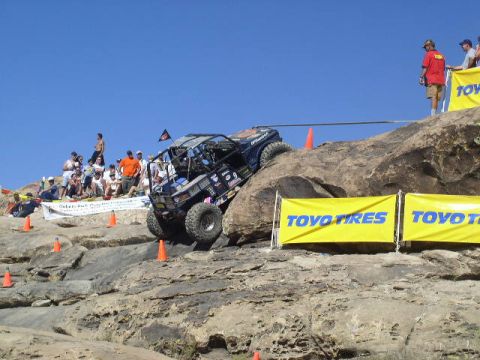 1979 Ford Bronco - An off-road vehicle navigates a steep, rocky course with spectators observing the event.