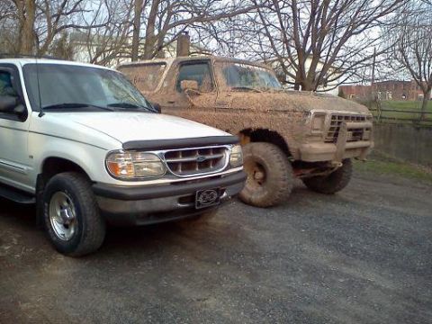 1979 Ford Bronco - Two Ford SUVs, a mud-caked Bronco and a clean Explorer, sit side-by-side.
