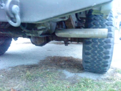 1995 Ford Bronco - Close-up view of a vehicle's rear axle and exhaust system, prominent off-road tires.