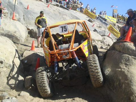 1979 Ford Bronco - A custom-built off-road buggy, marked with number 75, tackles a challenging rocky terrain during an event.