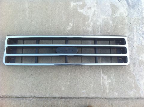 1990 Ford Bronco - This grille, identified as a 1990 Ford Bronco part, features a chrome surround and horizontal black bars.