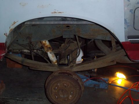 1989 Ford F-150 - The rear suspension and leaf springs of a 1989 Ford F-150 are visible, with a jack supporting the vehicle.