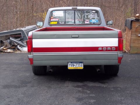 1989 Ford F-150 - This Ford F-150 pickup truck is seen from the rear, showing its distinctive red and white stripe detail.