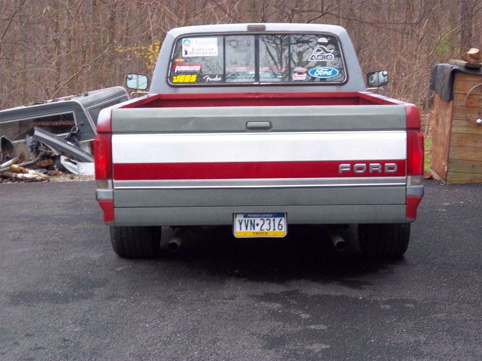 Rear view of a gray and red Ford F-150 pickup truck with a Pennsylvania license plate YVN-2316. Stickers are on the rear window