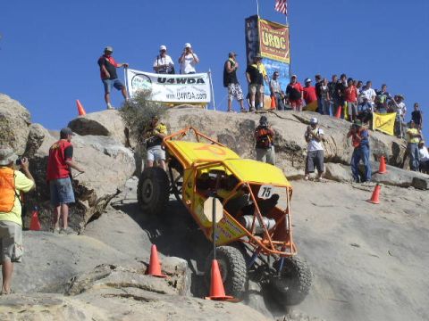 1979 Ford Bronco - Spectators watch an off-road buggy navigate a challenging rocky terrain during a competition.