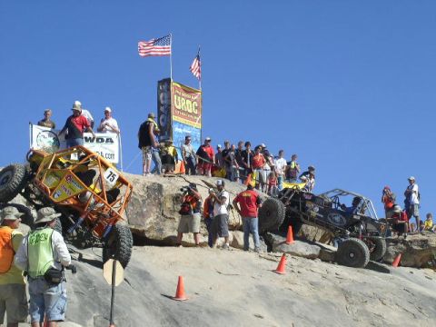 1979 Ford Bronco - Spectators watch as off-road vehicles tackle a challenging rocky terrain during an event.