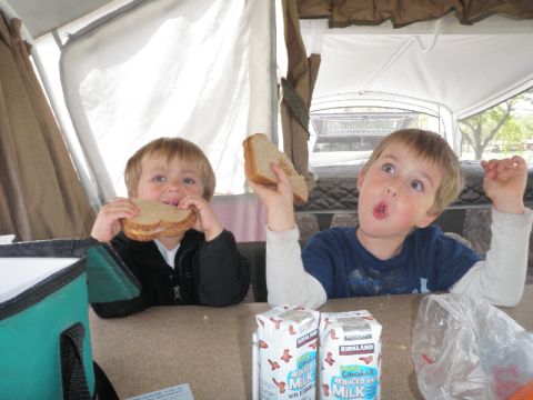 2007 Dodge 2500 - Two young boys enjoy sandwiches and milk inside a pop-up camper during an outdoor excursion.