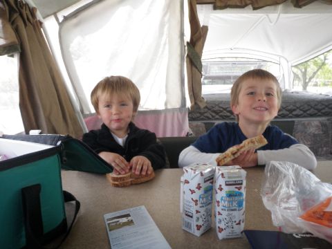 2007 Dodge 2500 - Two boys enjoy lunch inside a pop-up camper, with milk cartons and sandwiches on the table.