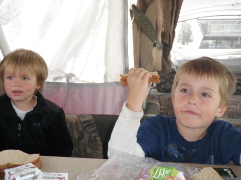 2007 Dodge 2500 - Two boys are eating sandwiches inside a camper. A truck is visible through the rear window.