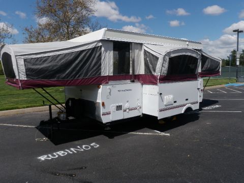 2007 Dodge 2500 - A Fleetwood Arcadia pop-up camper is shown parked in a lot, with the name 'RUBINOS' spray-painted on the asphalt.