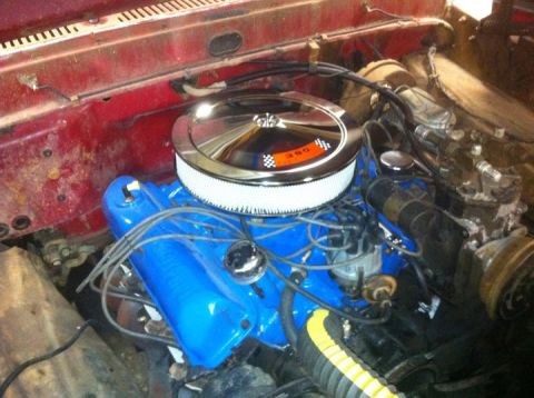 1986 Ford F-150 - Close-up of an engine bay bright blue valve covers and a chrome air cleaner with a "390" badge visible.