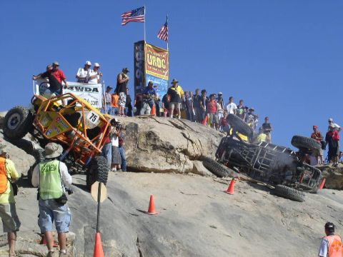 1979 Ford Bronco - Two off-road vehicles navigate a steep, rocky course with spectators watching from above.
