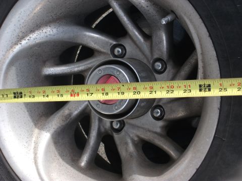 1996 Ford Bronco - A yellow measuring tape is placed across a vehicle's wheel hub, showing measurements from 11 to 25 inches.