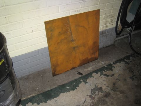 1979 Ford Bronco - A rusty metal plate with handwritten text sits on a concrete floor next to a brick wall.