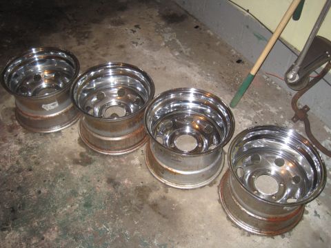 1979 Ford Bronco - Four chrome wheels are shown on a concrete floor.