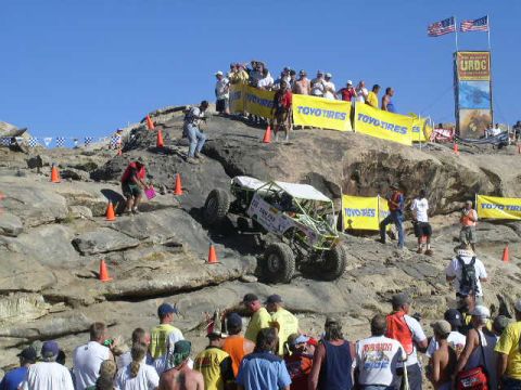 1979 Ford Bronco - An off-road buggy navigates a steep, rocky course with spectators observing the event.