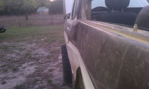 1979 Ford Bronco - This weathered SUV, seen from the side, appears to be a project vehicle with a lifted suspension and visible wear.