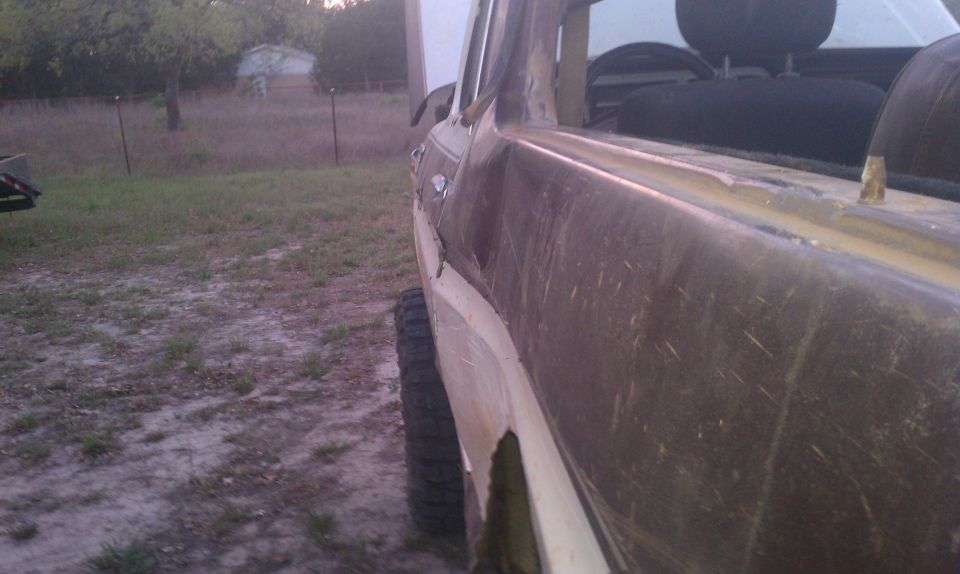 Side view of a weathered brown and white SUV with a lifted suspension