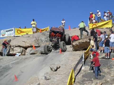 1979 Ford Bronco - Spectators watch an off-road buggy navigate a challenging rocky terrain during a competition.