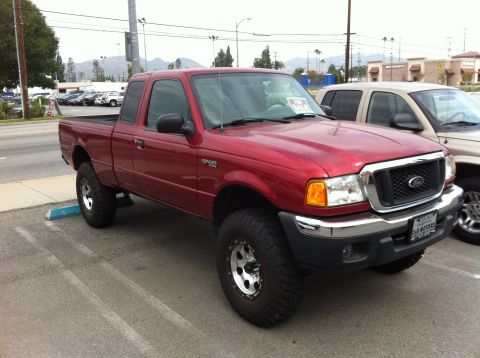1993 Ford Taurus - Red Ford Ranger pickup truck, likely from the early 2000s, parked in a lot with a "FOR SALE" sign visible.