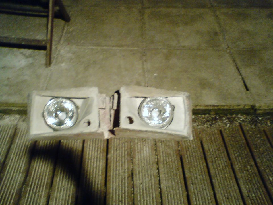 two headlights sitting on a wooden deck