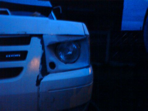 1989 Ford Bronco - The front corner of a white 1989 Ford Bronco shows damage to the bumper and headlight assembly.
