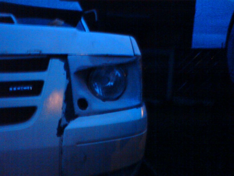 White 1989 Ford Bronco front corner with damaged bumper and headlight, viewed from the front-left