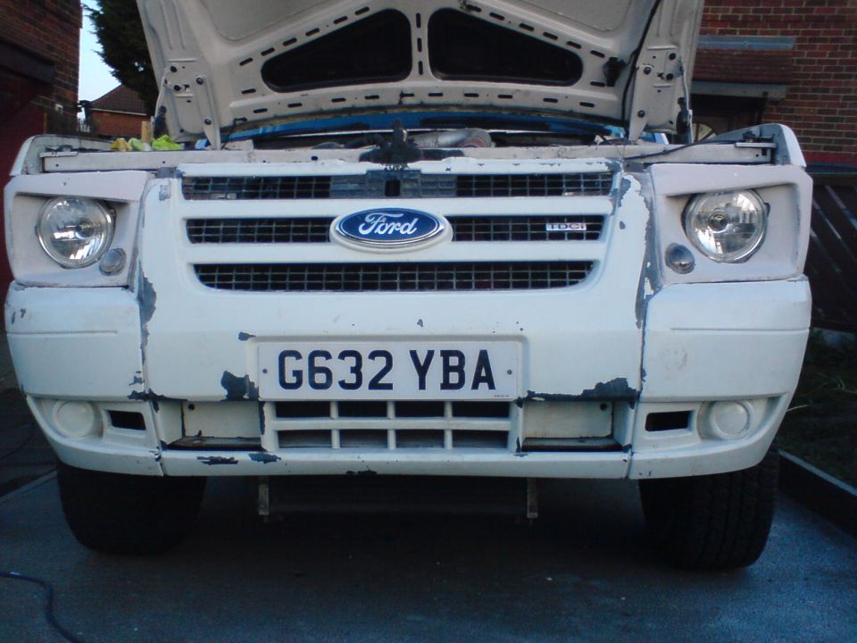 White Ford Transit van front end, hood open, showing peeling paint on bumper and grille. License plate G632 YBA