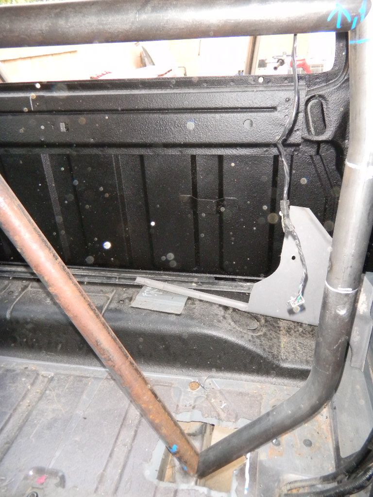 Truck bed interior with roll cage, black textured lining, and exposed metal