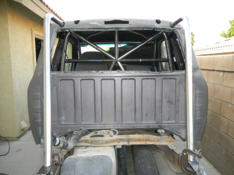 1997 Ford Ranger - This pickup truck has been modified with a substantial roll cage structure, obscuring the original rear window and bed.