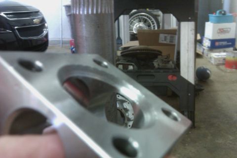 1999 Chevrolet Camaro - Metal part in focus, with a car and workshop items in the background.