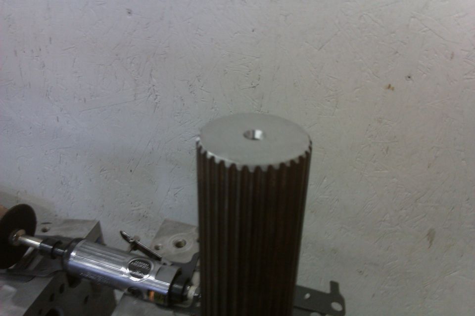 Splined shaft with a hole on top, next to a grinding tool. SUPERMOTORS.NET logo visible