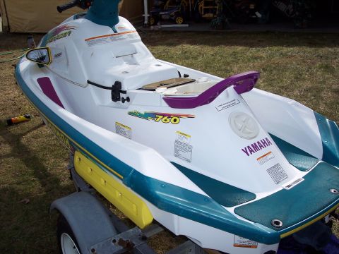 1996 Yamaha RA760 WaveRaider 2-P - A white and teal jet ski with purple accents sits on a trailer outdoors.