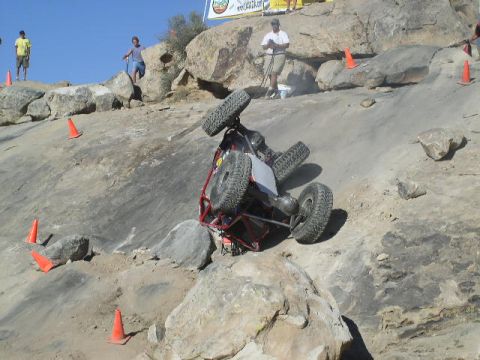 1979 Ford Bronco - An off-road buggy is stuck on its side during a competition on a rocky course.
