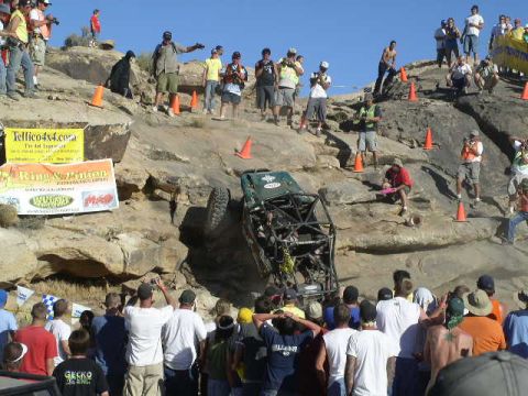 1979 Ford Bronco - A custom off-road vehicle navigates a steep, rocky terrain with onlookers observing the event.