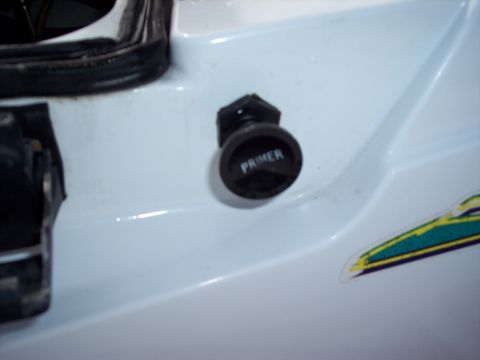 1996 Yamaha RA760 WaveRaider 2-P - Close-up of a primer button on a personal watercraft, indicating its function.