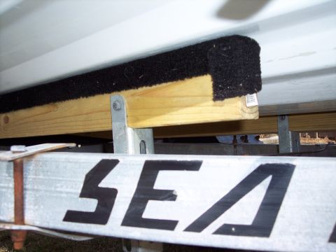 1996 Yamaha RA760 WaveRaider 2-P - Close-up view of a boat trailer bunk, a carpeted surface over wood, with part of the 'SEA' logo visible.