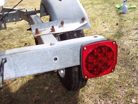 1996 Yamaha RA760 WaveRaider 2-P - Close-up of a boat trailer's rear section, showing a red LED tail light and a tire.