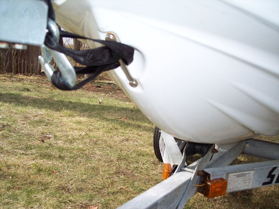 Close-up of a white personal watercraft secured with a strap and hook on a trailer