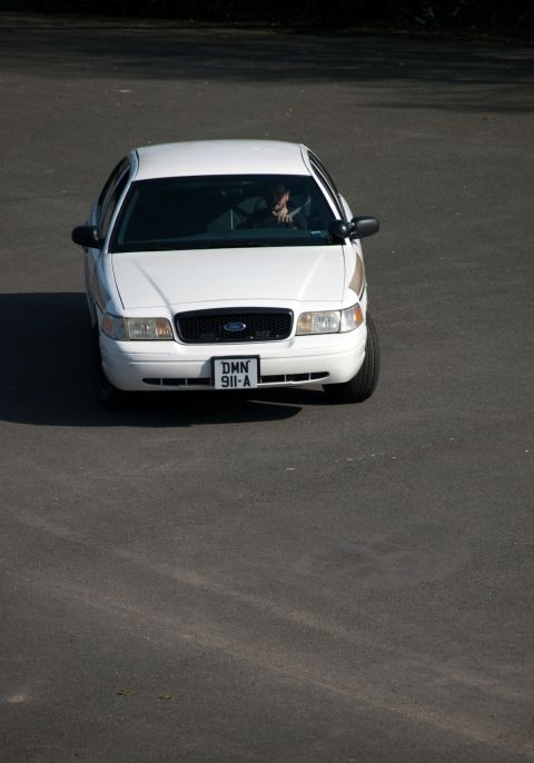 2001 Ford Crown Victoria - A white 2001 Ford Crown Victoria is seen from a high angle, driving on a paved surface.