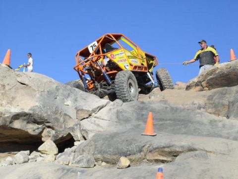 1979 Ford Bronco - A buggy navigates a challenging rocky course with assistance from a spotter.