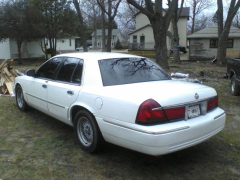 1999 Mercury Grand Marquis - Rear view of a white 1999 Mercury Grand Marquis sedan, chrome accents and wire wheels.