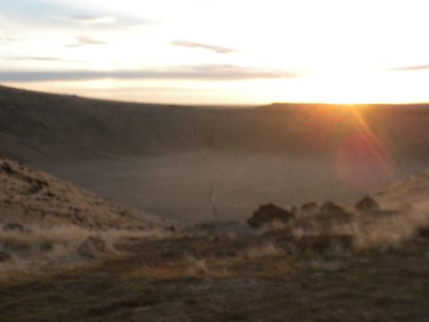 1989 Ford Bronco - The sun sets over a dusty, arid landscape with rolling hills and sparse vegetation.