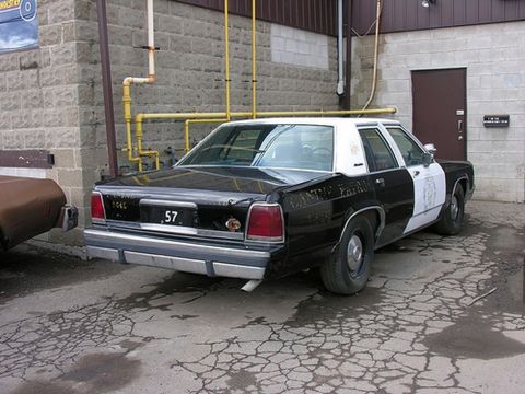 1991 Ford LTD Crown Victoria - This police car, likely from the 1980s, has 'CENTRAL PATROL' written on its side and license plate 57.
