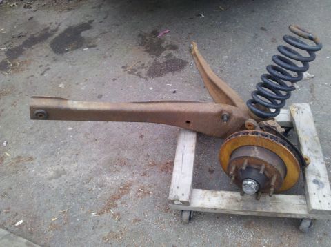 2003 Ford F-250 - This is a rusted suspension part, likely from a truck, with a coil spring and brake rotor attached.
