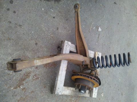 2003 Ford F-250 - This is a front suspension assembly, likely from a truck, showing the coil spring and brake components.